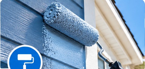 Paint roller applying fresh exterior paint